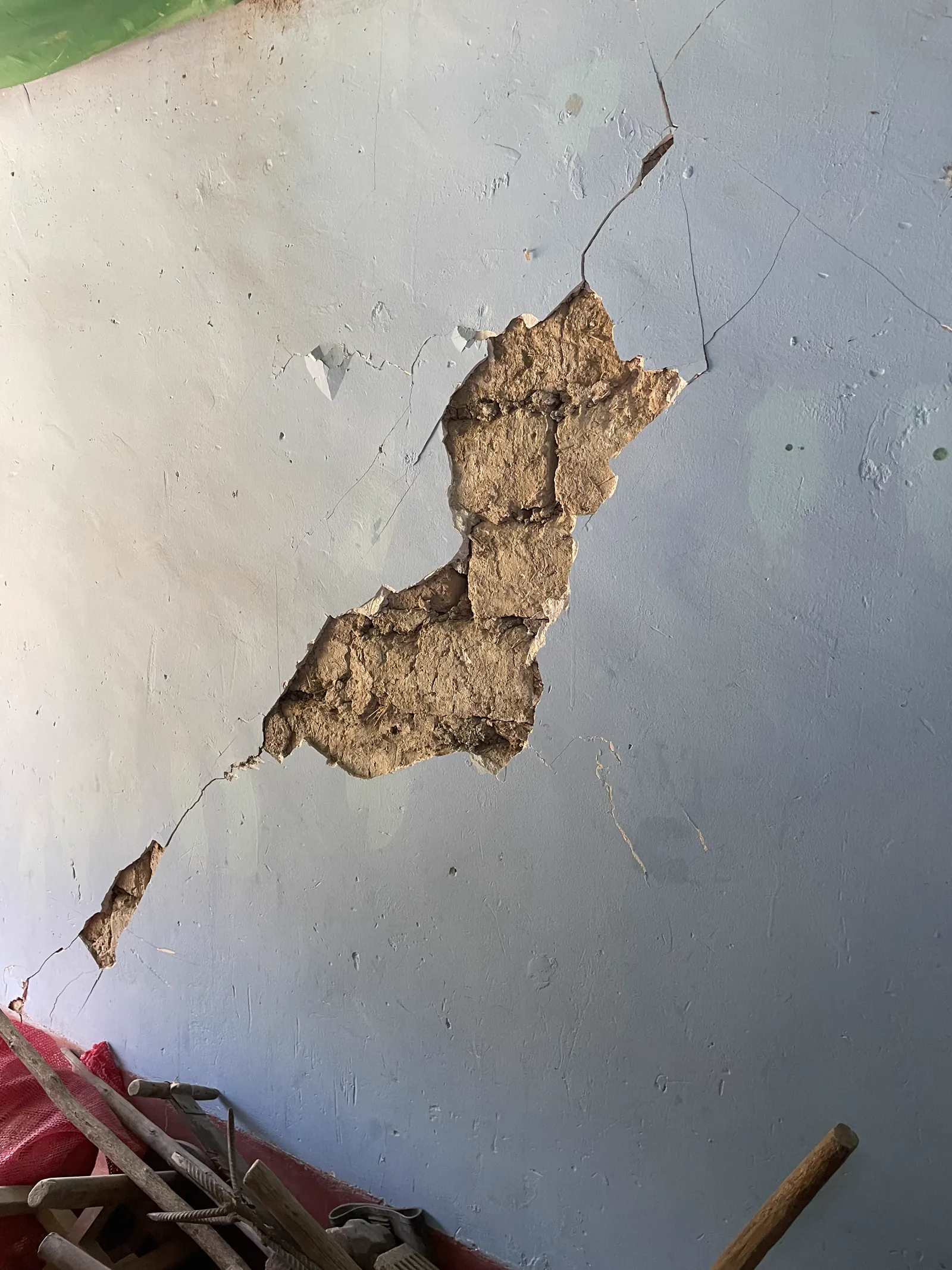 Fisuras y desprendimiento del tarrajeo que dejaron expuesto el muro de adobe